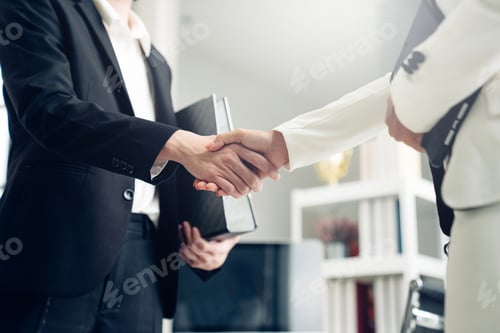 Preview: Businessmen and women making handshake in the office.