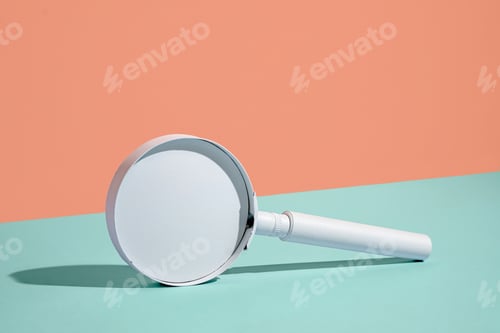 Preview: Plain white handheld magnifying glass balanced on edge