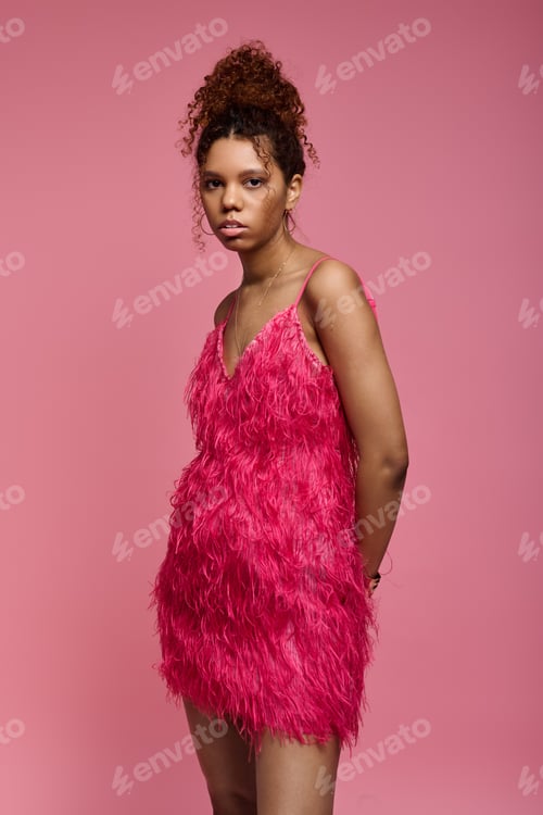 Preview: Young woman showcases vibrant fashion in an artistic pink setting with stylish flair