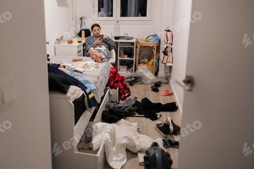 Preview: Teenage girl relaxing on bed in messy room