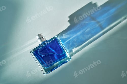 Preview: Blue perfume bottle casting shadows on surface