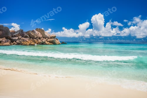 Preview: Grand Anse beach at La Digue island in Seychelles. Rolling wave at sandy beach with blue ocean