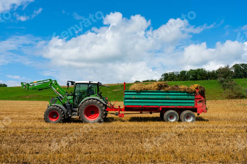 Preview: Agricultural combine, hauling a full hay wagon through a grassy field