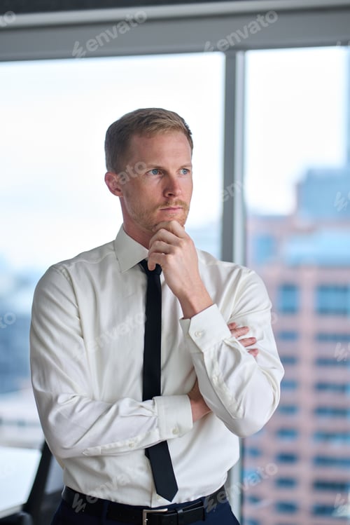 Preview: Confident thoughtful young businessman wearing tie thinking of future in office.