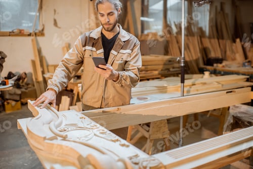 Preview: Carpenter working on smart phone at the carpentry