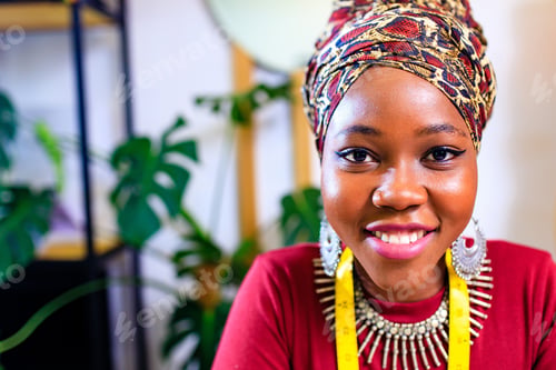 Preview: tanzanian woman with snake print turban over hear working in dressmaking shop