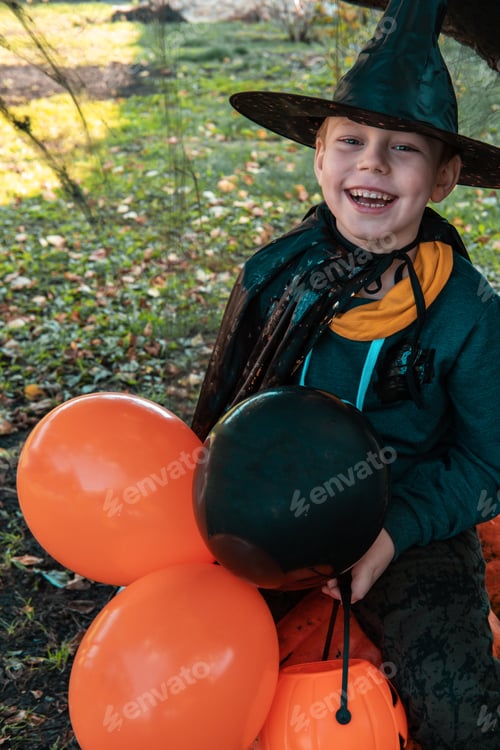 Preview: Halloween kids. Cute little boy with balloons on a pumpkin, child in witch hat