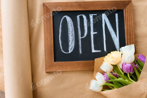 Preview: top view of beautiful tulips and open sign on craft paper