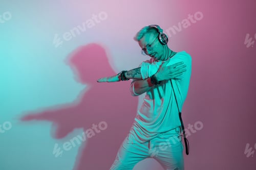 Preview: Handsome stylish dancer cool man in fashionable clothes dancing in colorful studio