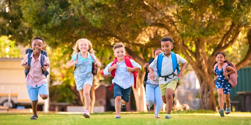 Preview: Multi-Cultural Primary Or Elementary School Students With Backpacks Running Outdoors At End Of Day