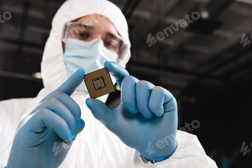 Preview: selective focus of microchip in hands of scientist wearing latex gloves