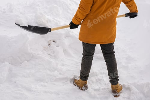 Preview: Close-up man is clearing the snow near house and on staircases hovelling at the winter season