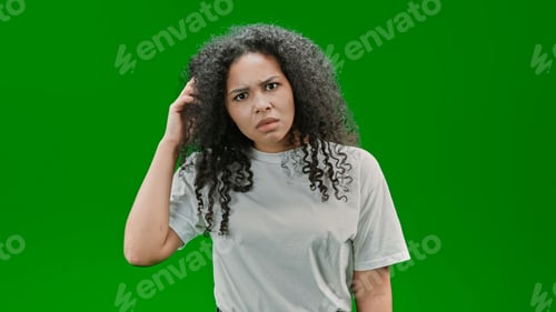 Preview: Scared curly girl standing against green background