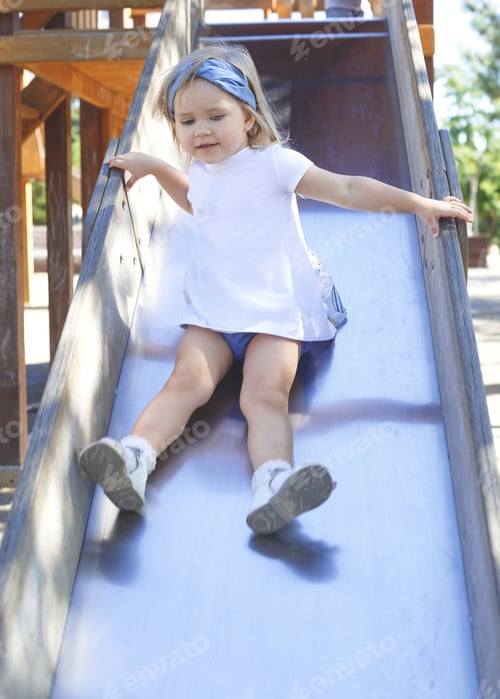 Preview: little blue-eyed girl plays in the playground.
