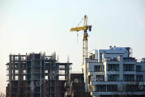 Preview: Tower cranes and high residential apartment buildings under construction. Real estate development.