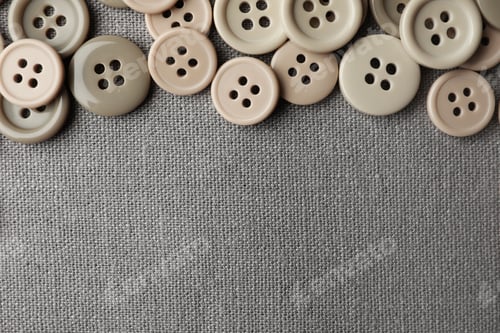 Preview: Many plastic sewing buttons on grey fabric, flat lay. Space for text