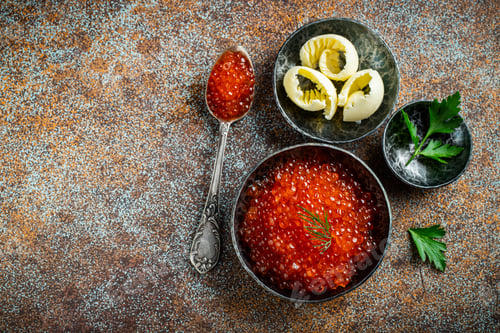 Preview: Delicious red caviar in black bowl.