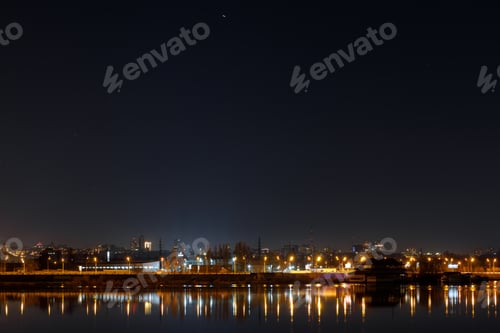 Preview: dark cityscape with buildings, lights and river at night