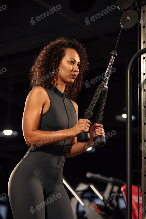 Preview: Muscular young fitness sports woman workout with dumbbells in fitness gym.
