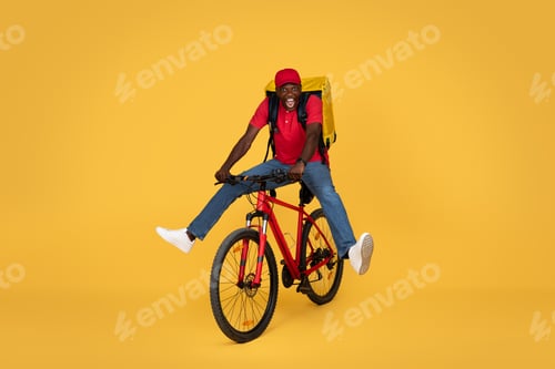 Preview: Glad young african american delivery man in uniform with big backpack and open mouth, has fun