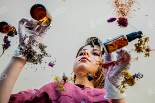 Preview: woman perfumer preparing herbs and flowers for make a perfume.