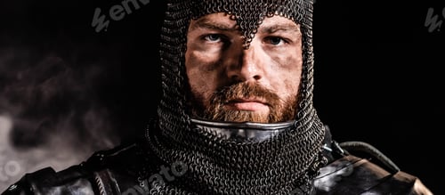 Preview: panoramic shot of handsome knight in armor looking at camera on black background