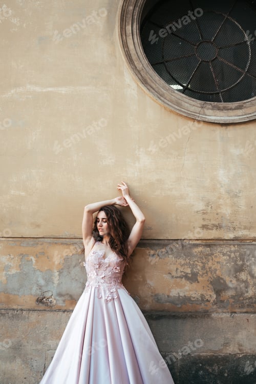 Preview: Woman in Gown Posing Against Weathered Urban Wall