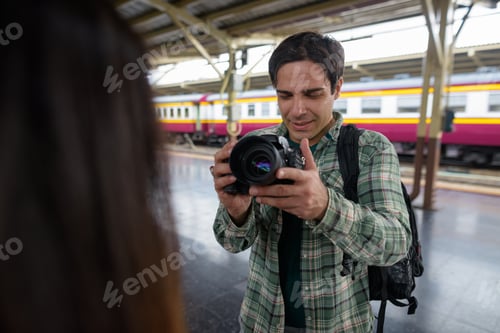 Preview: Man photographer taking picture of woman in train station