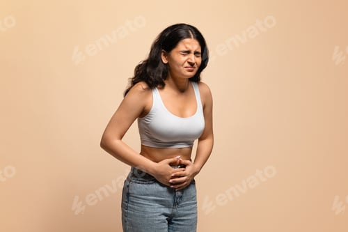 Preview: Stomach Pain. Sick young indian woman suffering from acute abdominal ache