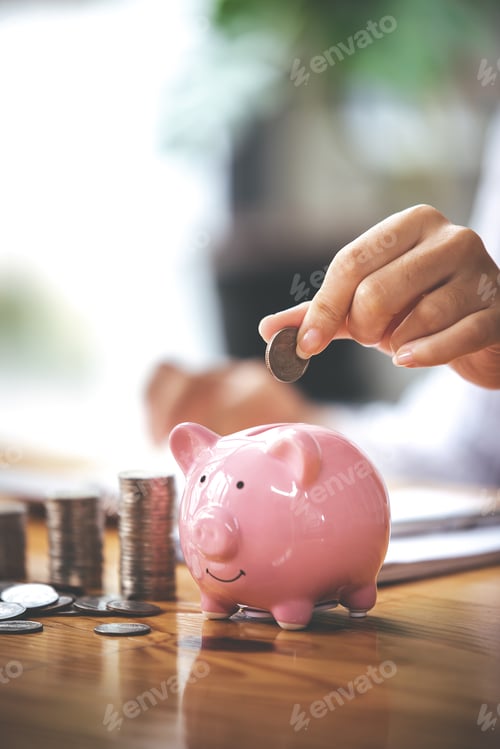 Preview: businessman holding a coin in a piggy bank On a table with sunlight. Money Saving Ideas for Financia