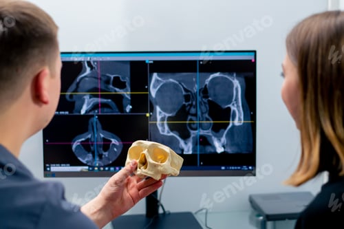 Preview: the radiologist doctor looks at the screen on which the 3D image of the nose scan shows the patient