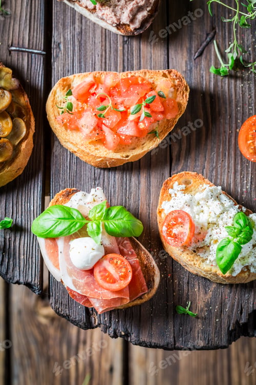 Preview: Crisp mix of bruschetta with fresh ingredients on wooden table
