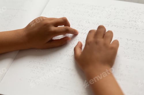 Preview: Blind schoolboy hands reading a braille book in classroom at elementary school