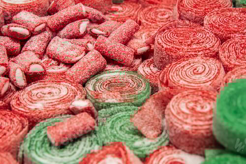 Preview: Set of red and green rolled chewing candies, close up.