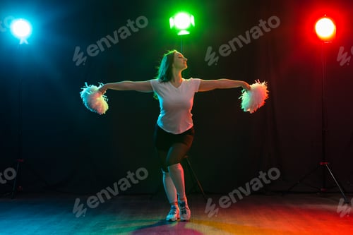 Preview: Full length portrait of cheerleader dancing with pom-poms
