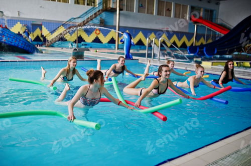Preview: Fitness group of girls doing aerobical excercises in swimming pool