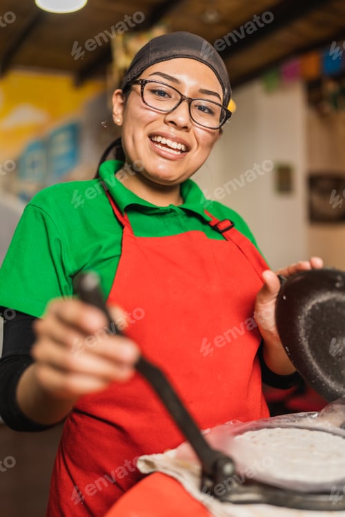 Preview: Cool worker preparing tortillas for mexican tacos in a restaurant