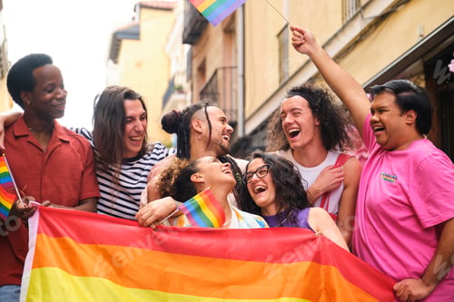 Preview: A group of people are holding rainbow flags and laughing at Pride Parade.