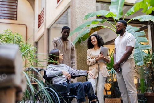 Preview: Multiracial coworkers discussing business strategy with disabled colleague in wheelchair