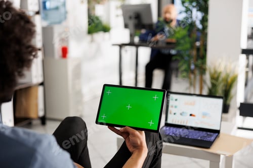 Preview: Employee holding tablet with green screen in hand