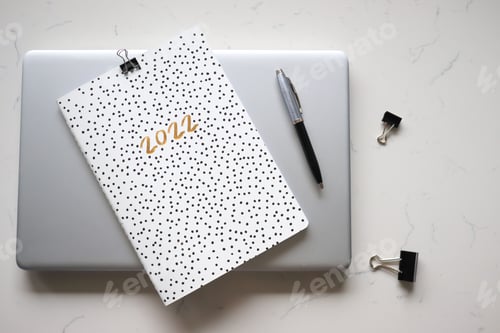 Preview: Calendar for 2022 ,planner, pen, laptop, items flat lay, minimalist.Minimal flat lay