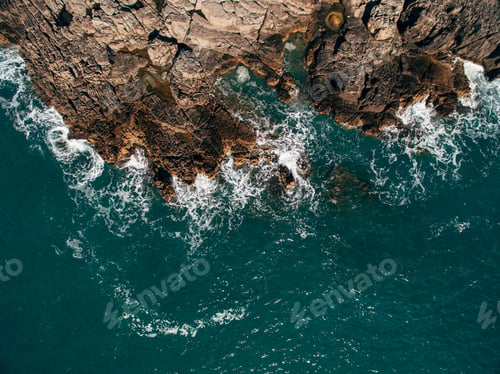 Preview: A drone shot of a beautiful rocky beach with clear turquoise sea water.