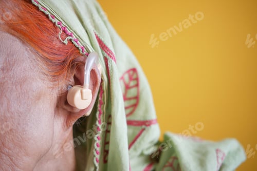 Preview: Hearing aid concept, a senior women with hearing problems.