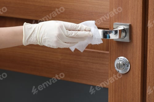 Preview: Person disinfects and cleans door handle with antibacterial wet wipes to protect against viruses,