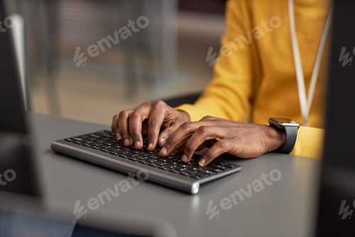 Preview: Close up of male hands typing at keyboard while using computer in office