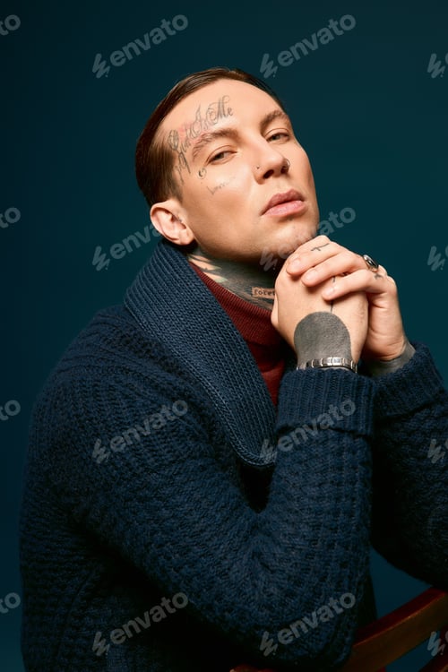Preview: Stylish young man poses elegantly in contemporary fashion, showcasing a confident demeanor