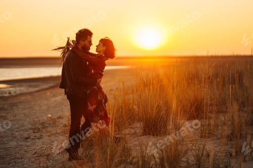 Preview: Enjoying time together. Stylish and loving couple enjoying each other by the sea.