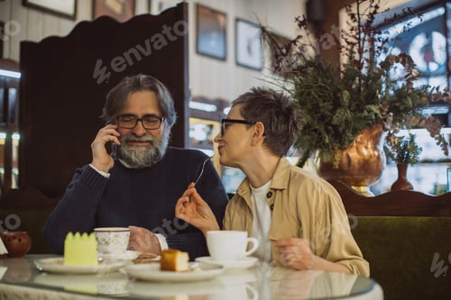 Preview: Mature couple enjoying coffee, calling on phone