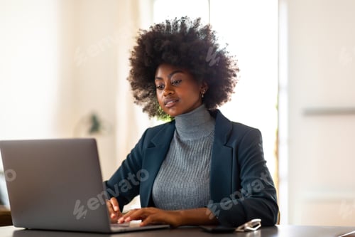 Preview: African female entrepreneur working on laptop at office