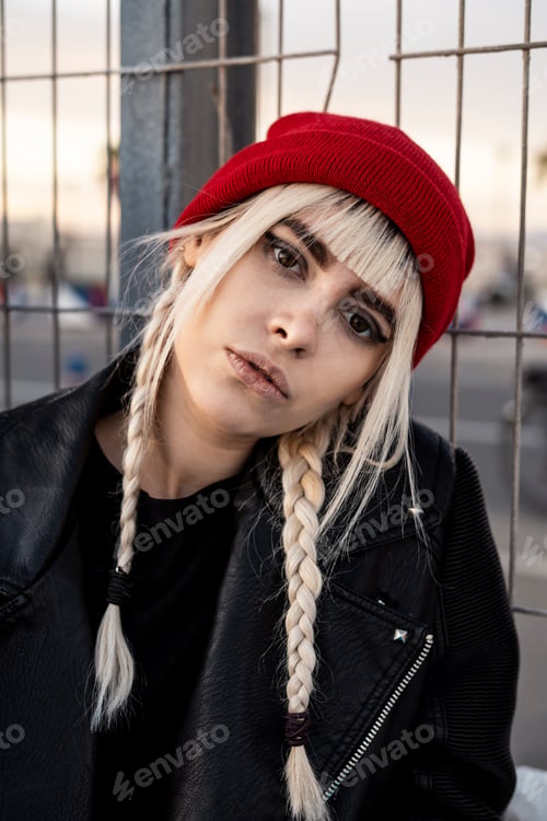 Preview: Portrait of young woman with blond braids wearing red woolly hat